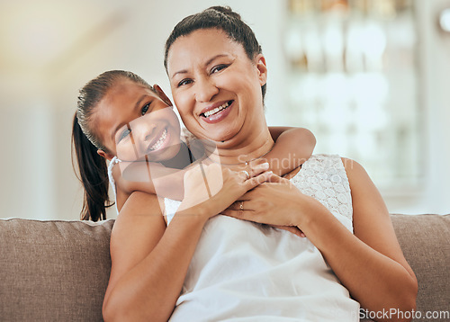 Image of Love, hug and grandmother portrait with granddaughter bonding at home on the living room sofa. Mature woman embracing and hugging or cuddling with her little grandkid for relaxing care and bond