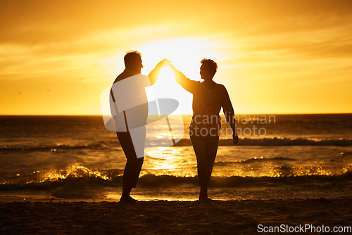 Image of Love, ocean and sunset, silhouette of couple on beach holding hands in Bali. Waves, romance and man and woman dancing in evening sun on romantic vacation spending time together in nature and sea sand