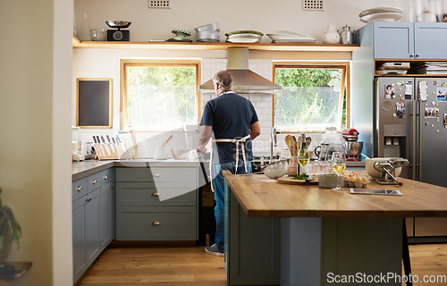 Image of Cooking, breakfast and man in the kitchen of a house for healthy food, diet and lunch. Back of a mature and hungry chef in retirement with dinner, baking or easy meal in a home in the morning