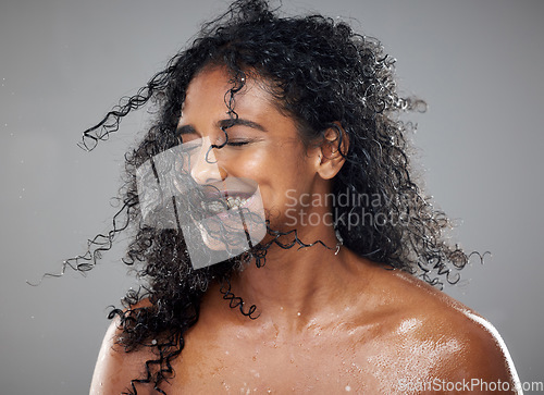 Image of Healthy, wet hair and skincare beauty of a black woman with cosmetics product mockup to hydrate, nourish and moisturize African hair. Clean skin health, cosmetics treatment and gray studio background