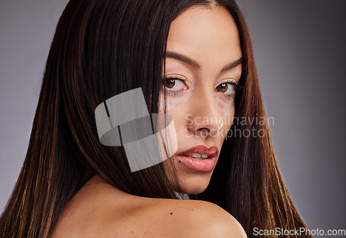 Image of Beauty, vitiligo and portrait of a woman with a skincare treatment for wellness, health and cosmetics. Natural face, piebald skin and model from Mexico isolated in a studio with a gray background.