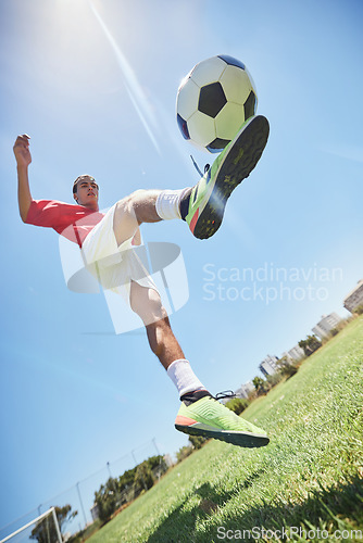 Image of Football, fitness and soccer player training with a juggling exercise on soccer field, grass or football stadium. Sports, jumping and below view of a healthy athlete with skills and creative talent