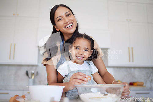 Image of Mother, baking and bonding of a girl with mama learning in a home kitchen with a smile. Portrait of a happy black mom with cooking, love and care holding her kid in a house together smiling