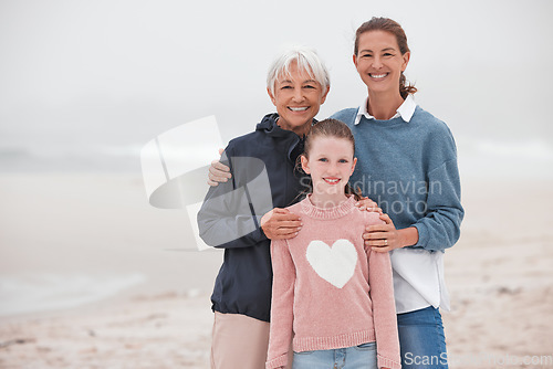 Image of Mother, grandma and child at beach in portrait, bonding or love in winter, mist or cloud by sea. Mom, girl and senior for smile, happy or care in family, happiness or together at ocean on vacation