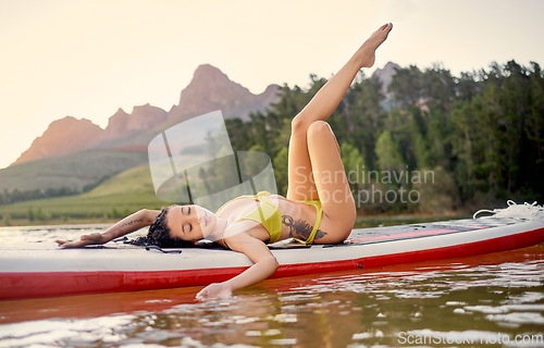 Image of Relax, holiday and a woman on a board in a lake for freedom, travel and water activities. Calm, summer and a young girl in a river for adventure, zen and vacation by the dam for relaxing at sunset