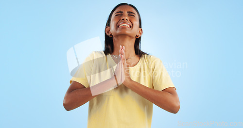 Image of Woman, praying and worship for faith and religion in studio, guide with help and trust God on blue background. Desperate, anxiety and prayer, sorry or forgiveness with pain, gratitude and spiritual