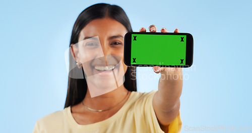 Image of Cellphone green screen, studio portrait and happy woman show web announcement, mobile info or app chroma key UI. Tracking markers, smartphone mockup space and Indian person face on blue background