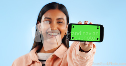 Image of Phone green screen, studio portrait and happy woman show online presentation, social media info or commercial news. Tracking markers, smartphone chroma key and mockup space person on blue background