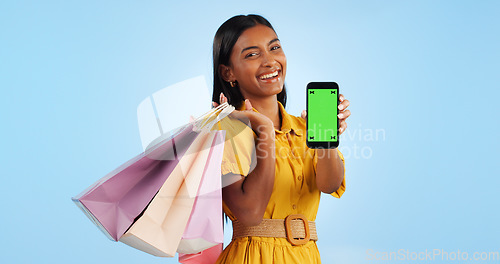 Image of Smartphone green screen, shopping bag and portrait of happy woman show online shop, retail market or studio omnichannel. Tracking markers, phone chroma key or mockup space customer on blue background