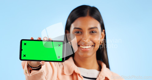 Image of Smartphone green screen, studio portrait and happy woman show internet connection, mobile promotion or app chroma key. Tracking markers, cellphone mockup space and tech person face on blue background