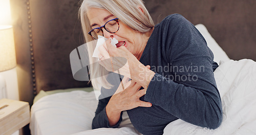 Image of Sick, blowing nose and senior woman in bed with allergies, flu or cold on weekend morning at home. Illness, sneezing and elderly female person in retirement with tissue for sinus in bedroom at house.