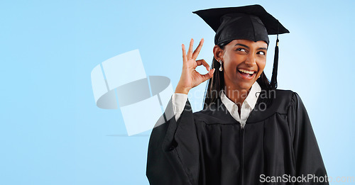 Image of Woman, graduation and space with ok sign, studio and review for vote, choice or support by blue background. Student girl, thinking and celebration for icon, emoji and decision for mockup with goals