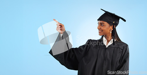Image of Graduation student, studio and happy woman point at learning news, university info or college development. Mockup space, promotion and graduate gesture at education opportunity on blue background
