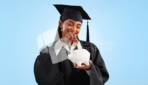 Image of Woman, graduation and piggy bank in studio, saving and cash for investing, future or goals by blue background. Student girl, banking and money with thinking, decision and choice for financial plan