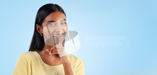 Image of Secret, portrait and woman with finger on lips, whisper and announcement on a blue background. Person, face or model with privacy, mockup space or drama news with surprise, emoji or gossip with shush