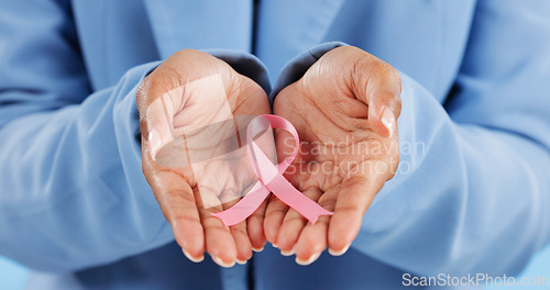 Image of Hands, pink ribbon and breast cancer support with awareness and healthcare icon on blue background. Person in studio, medical symbol and wellness with care, trust and kindness in solidarity campaign