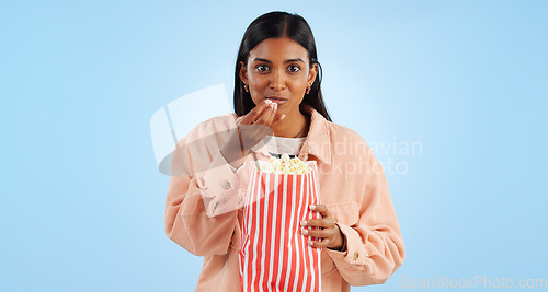 Image of Portrait, watching tv and woman with popcorn, excited and happiness on a blue studio background. African person, girl or model with cinema snack, eating a treat or streaming a movie with mockup space