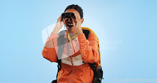 Image of Hiking journey, binocular and studio woman watch trekking, backpacking or travel adventure view, sightseeing or bird watching. Wow, search discovery and explorer see destination on blue background