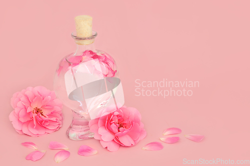 Image of Rose Flower Perfume in Heart Shaped Bottle with Pink Roses 