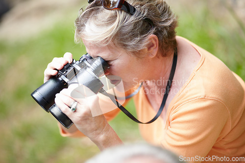 Image of Senior, woman and binocular in forest for travel, sightseeing or vacation and scenery in nature. Elderly, lady or person in woods for holiday, adventure or experience with hiking, explore or activity