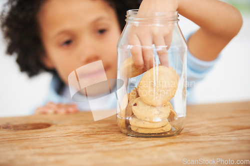 Image of Cute, cookie jar and boy child by the kitchen counter eating a sweet snack or treat at home. Smile, dessert and hungry young kid enjoying biscuits by a wooden table in a modern family house.