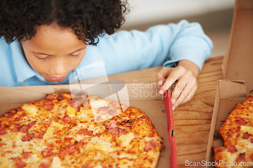 Image of Child, boy and pizza takeaway box for hungry snack, junk fast food dinner at kitchen table. Male person, kid and hawaiian pineapple bacon meal or joy reward eating or unhealthy diet, carbs for lunch