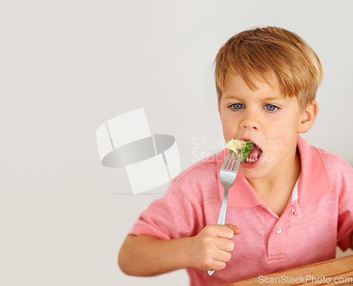 Image of Child, broccoli or vegetables fork eat for healthy nutrition meal, dinner hunger at kitchen table. Male person, kid and hand wall background or fibre lunch for development, youth or organic taste