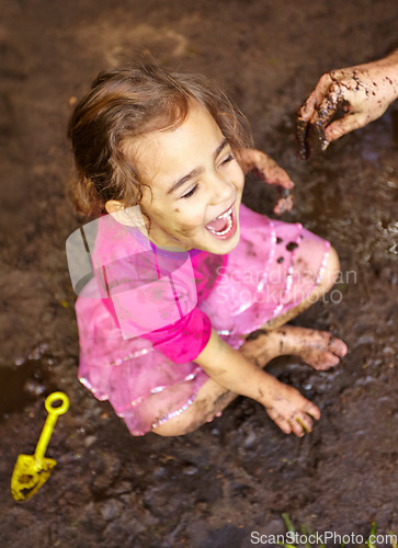 Image of Girl, child and fun with laugh in mud for freedom, playing and muddy in sunshine weather or outdoor. Kid, female person and face with happiness for activity, enjoyment and relax with toy in cirt