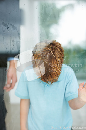 Image of Sad, child and home by window to play outside, anxiety and lonely for fear, conflict and trauma in family. Young, boy and depression for stay indoor, glass or mental health for balance childhood