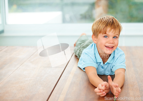 Image of Happy, portrait and young child on floor in family home, wellness and playing games in lounge. Boy, face and smile in living room for fun, care and excited english kid, growth and toddler development