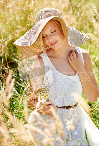 Image of Summer, hat and smile with woman in field for travel, vacation and holiday. Relax, peace and nature with female person and grass in countryside meadow for calm environment, spring and sunshine