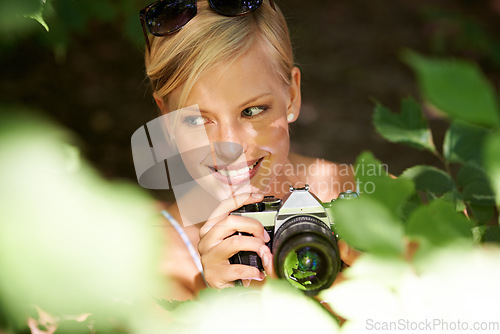 Image of Smile, photographer and nature with woman in forest for trees, environment and relax. Shooting, camera lens and photography with face of female person in woods for travel, torusim and summer