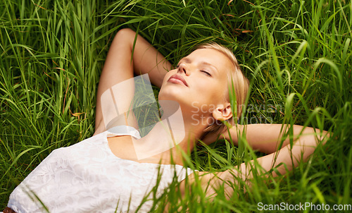 Image of Nature, grass field and relax woman sleeping, tired or nap for outdoor stress relief, morning wellness or rest. Fatigue, eyes closed and person dream, comfort and exhausted on natural green pitch