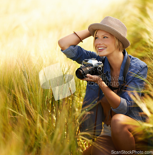 Image of Woman, camera and photography with happy travel, vacation and holiday with wheat field and plants. Nature, photographer and outdoor with blog and countryside with photo for adventure and journey