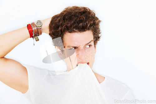 Image of Thinking, confused and a man biting his tshirt in studio isolated on white background for crazy style. Face, doubt or expression with a young model scratching his head, looking clueless about an idea