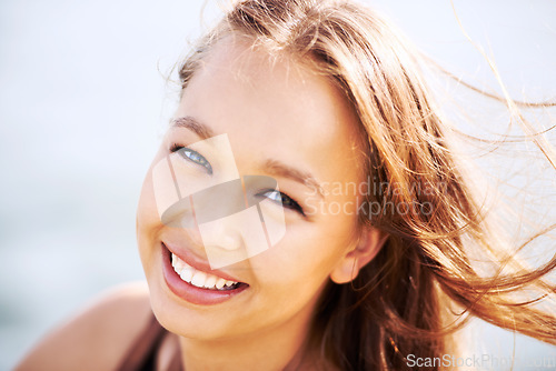 Image of Portrait, beauty and happy woman with wind in hair outdoor, cosmetics and wellness in summer. Face, confidence and smile of attractive person or girl for facial, natural and healthy skin in Spain
