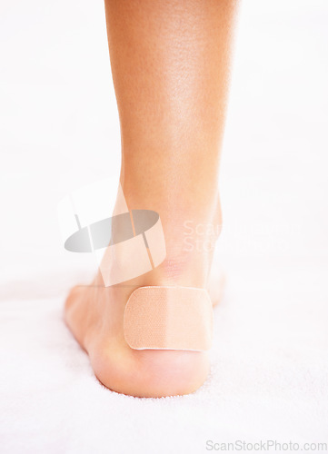 Image of Closeup of person with injury, foot and plaster, skin and wound with health and medical aid on white background. Healthcare, bandage on blister and wellness with medicine, help and accident in studio