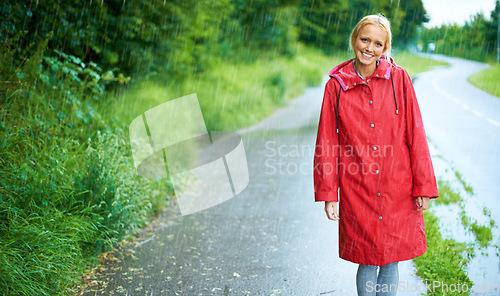 Image of Woman, smile and raincoat in outdoor rain, wet and cold from weather, winter and nature. Happy female person, road and red jacket is trendy, rainfall and protection from water, face and holiday