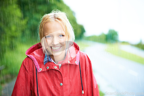 Image of Woman, smile and raincoat in outdoor weather, wet and cold from rain, winter and nature. Happy female person, fashion and red jacket is stylish, rainfall and protection from water, face and portrait