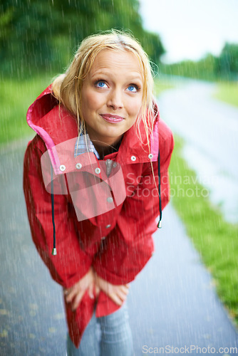 Image of Woman, rain and raincoat in nature, thinking and cold from weather, winter and outdoors. Female person, wet and red coat for fashion on trip, rainfall and protection from water, vacation and holiday