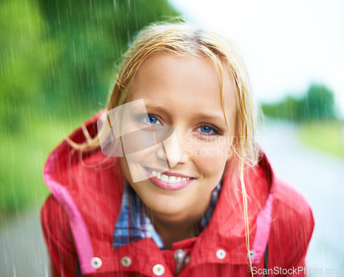 Image of Woman, smile and raincoat in nature rainfall, wet and cold from rain, weather and outdoors. Happy person, fashion and red coat in portrait, storm and protection from water, vacation and travel