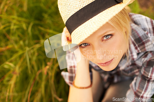 Image of Nature, portrait and young woman with straw hat sitting in an outdoor garden for fresh air. Serious, fashion and female person from Australia in the forest, woods or field with casual style.