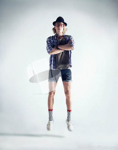 Image of Portrait, jumping and man with fashion, retro and streetwear with confident guy isolated on a white studio background. Person, model and hipster with casual outfit, trendy clothes and floating in air