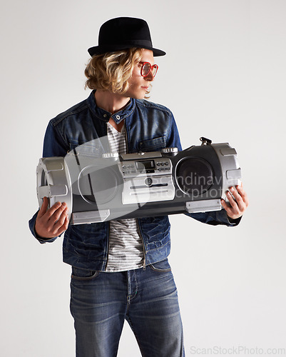 Image of Boombox, fashion and retro style of a man in studio with music, radio or audio sound and noise. Male model person on a white background with denim outfit, glasses and hipster hat to listen to song