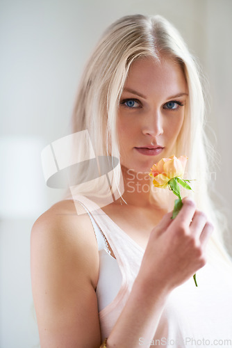 Image of Portrait, woman and holding of flower in bedroom for romance with headshot in Norway. Female person, looking and hand with rose for love, trust or care in relationship for growth, bond and partner