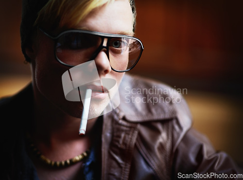 Image of Portrait, addiction and a boy smoking a cigarette closeup for nicotine or tobacco dependency in sunglasses. Face, smoke and bad habit with a young person inhaling an addictive substance for cancer