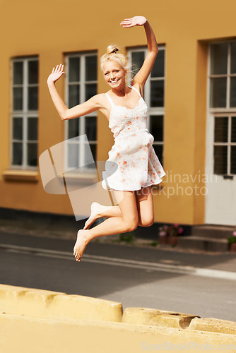 Image of Portrait, smile and jump with a woman during summer in her neighborhood for freedom or energy for life. Fashion, excited and a happy young person feeling carefree in an old town or city for adventure