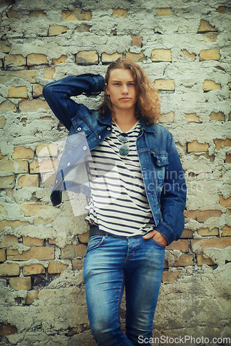 Image of Man, portrait and fashion, streetwear and denim clothes with hair and relax against wall background. Urban, young and gen z with serious model outdoor, casual outfit and hipster, cool and trendy