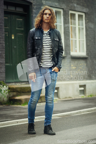 Image of Man, portrait and fashion, streetwear and clothes with hair and pose in street or city in denim. Urban, young and gen z with serious model outdoor, casual outfit and hipster, cool and trendy