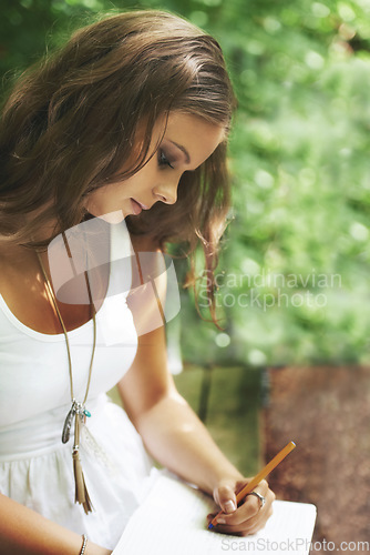 Image of Park, peace and a woman writing in a book outdoor during summer for mental health or expression. Creative, journal and idea with a young person in a green garden to relax for wellness or freedom